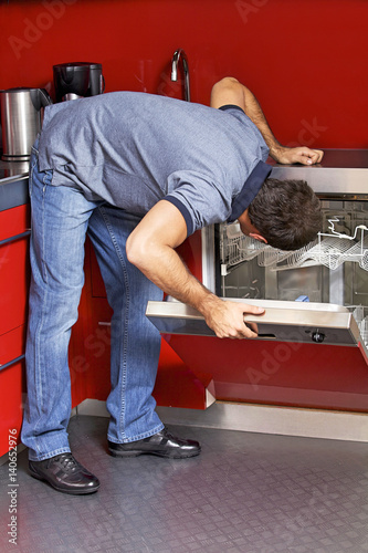 Young man looking at dish washer