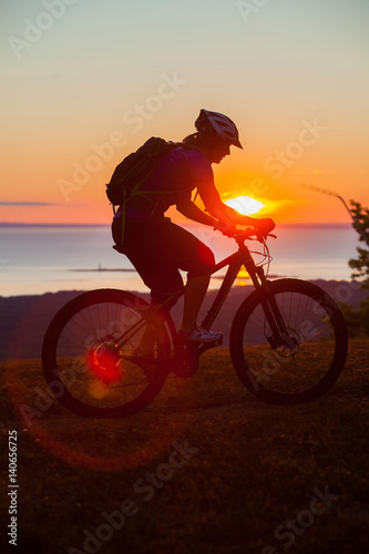 Woman mountain biking on single track trail at Sunset