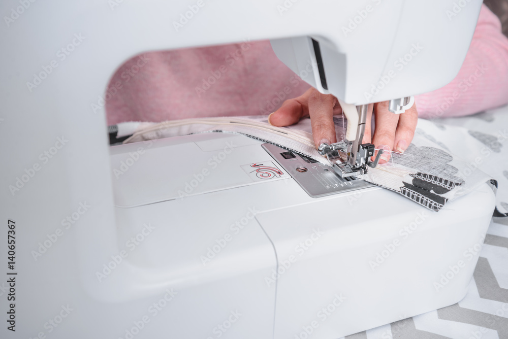 beautiful woman seamstress sew on the sewing machine clothes.