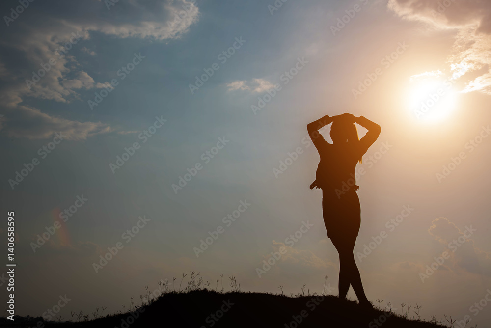 Silhouette woman with hands raised and sky with sunlight Silhouette woman with hands raised and sky with sunlight