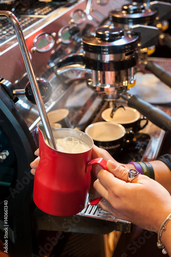 Preparing the coffee and cappuccino at the espresso machine.