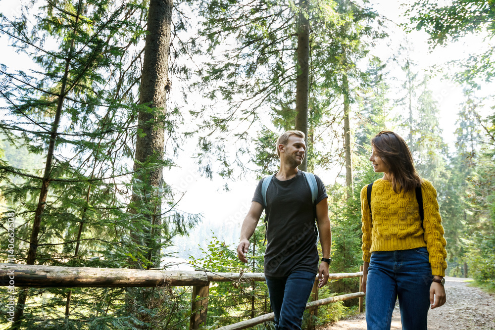 Young couple looking at each other, walking in mountains' forest. Young couple looking at each other, walking in mountains' forest.