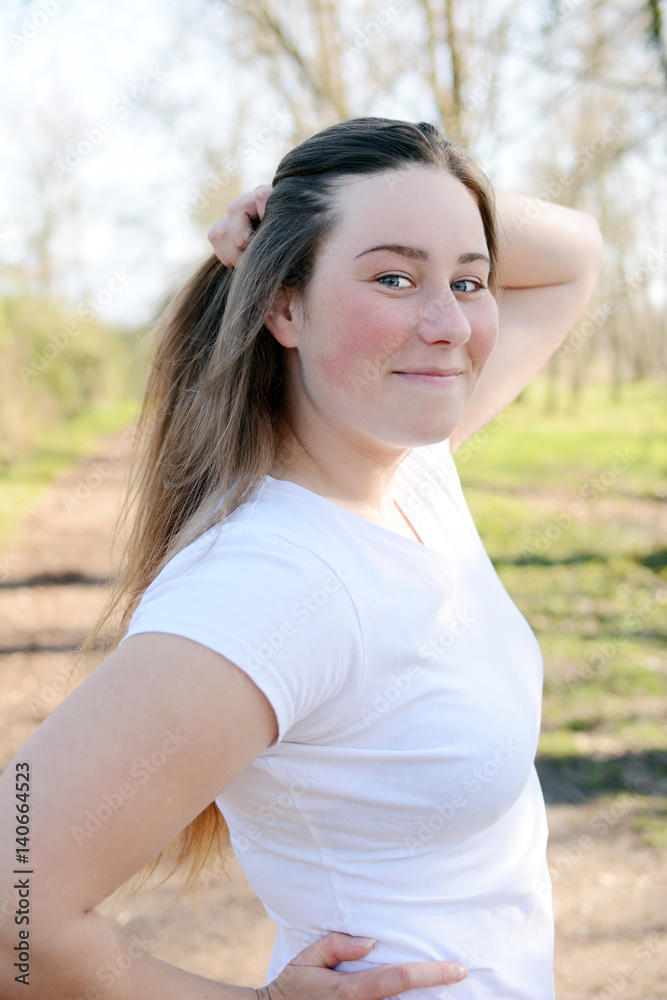 Portrait of happy beautiful young woman enjoying sun light in the park.