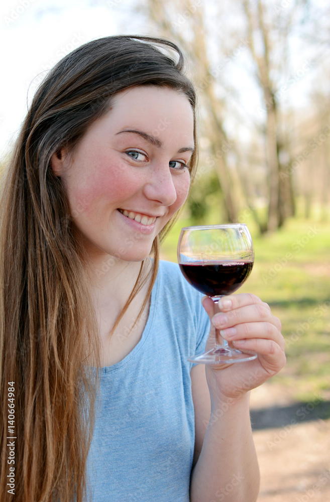 Beautiful young woman drinking wine in the park. Beautiful young woman drinking wine in the park.