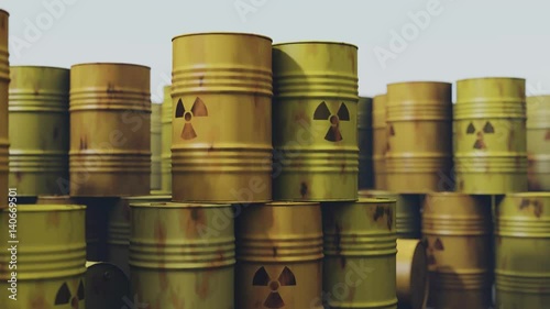 Many rusty barrels with nuclear waste are stacked on top of each other.