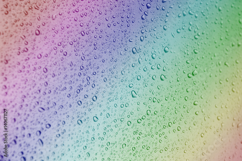 Close up to rainbow color water drops on glass with selective focus