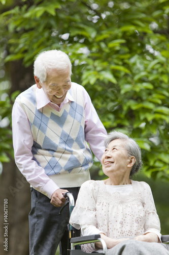 Senior Man Pushing Wife in Wheelchair photo