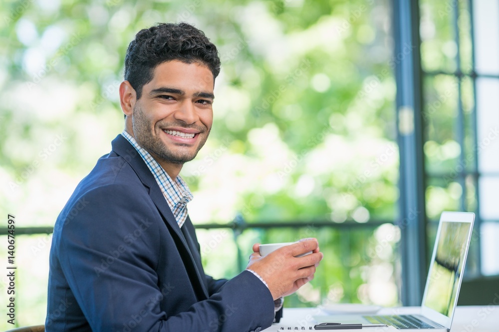Happy businessman holding coffee cup in a restaurant Happy businessman holding coffee cup in a restaurant