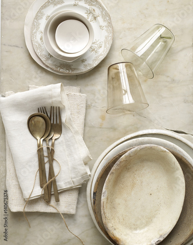 Beige dishes on marble with twine and linen. photo