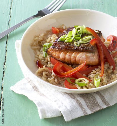 Salmon with brown rice and peppers in a bowl.