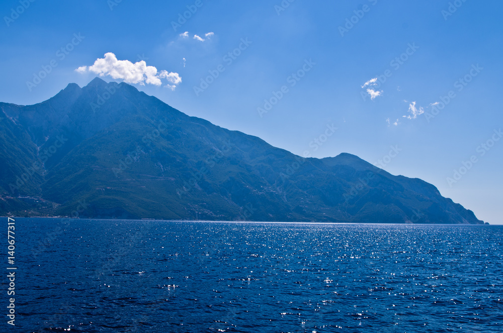 Aegean sea, silhouette of the holy mountains Athos and a small cloud above the mountain top, Chalkidiki, Greece