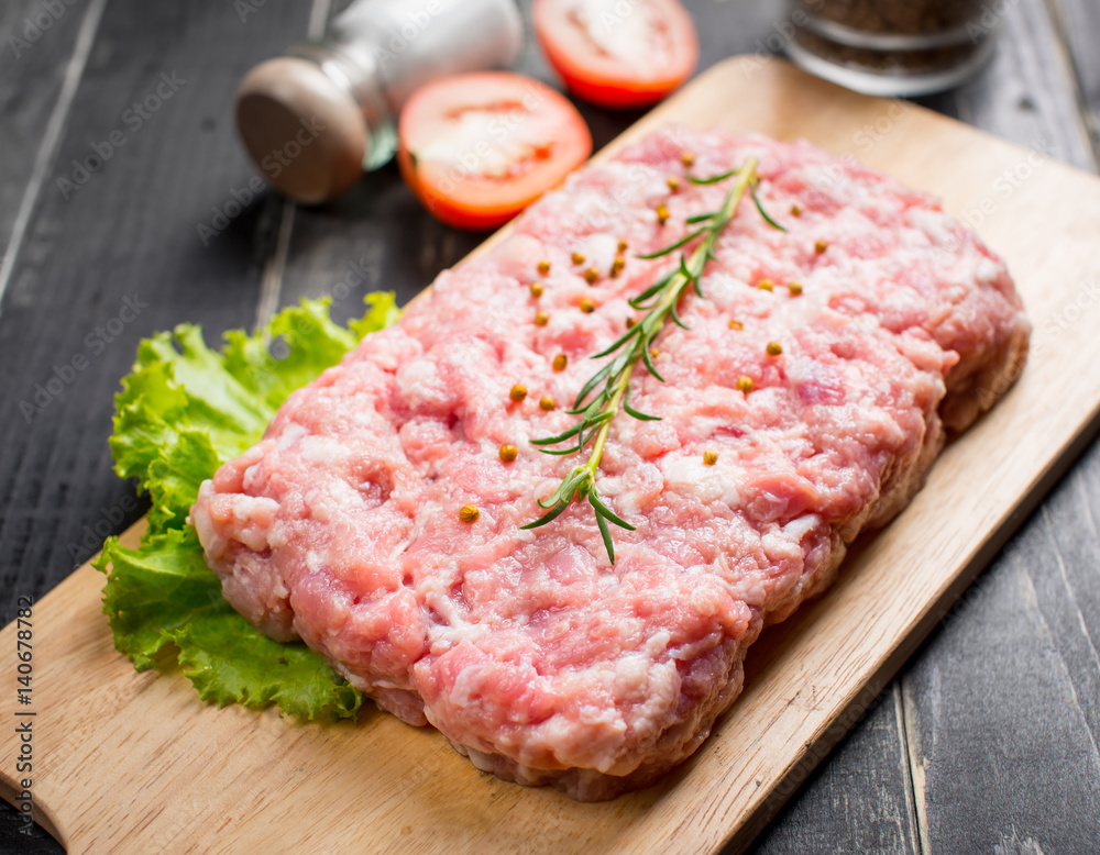 Minced pork uncooked with cutting board on wood background Minced pork uncooked with cutting board on wood background