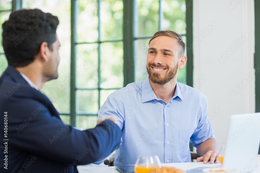 Fotografie Businessmen shaking hands with each other