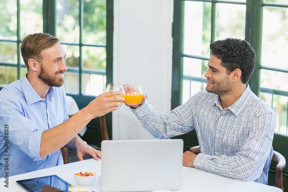 Happy executives toasting glasses of juice Happy executives toasting glasses of juice