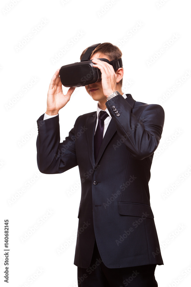 Young handsome businessman in black suit wearing virtual reality goggles., isolated on white background Young handsome businessman in black suit wearing virtual reality goggles., isolated on white background