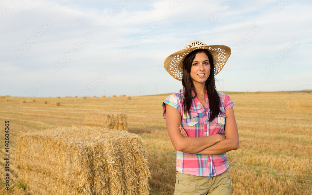 Countryside woman at harvested wheat field. Farming and rural agriculture work success concept.