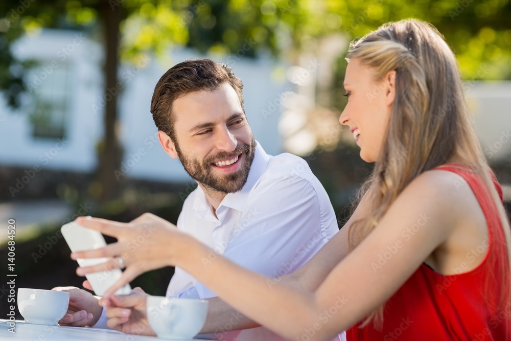 Couple using mobile phone in a restaurant Couple using mobile phone in a restaurant