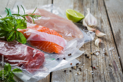 Beef, chicken and salmon in vacuum plastic bag for sous vide cooking photo