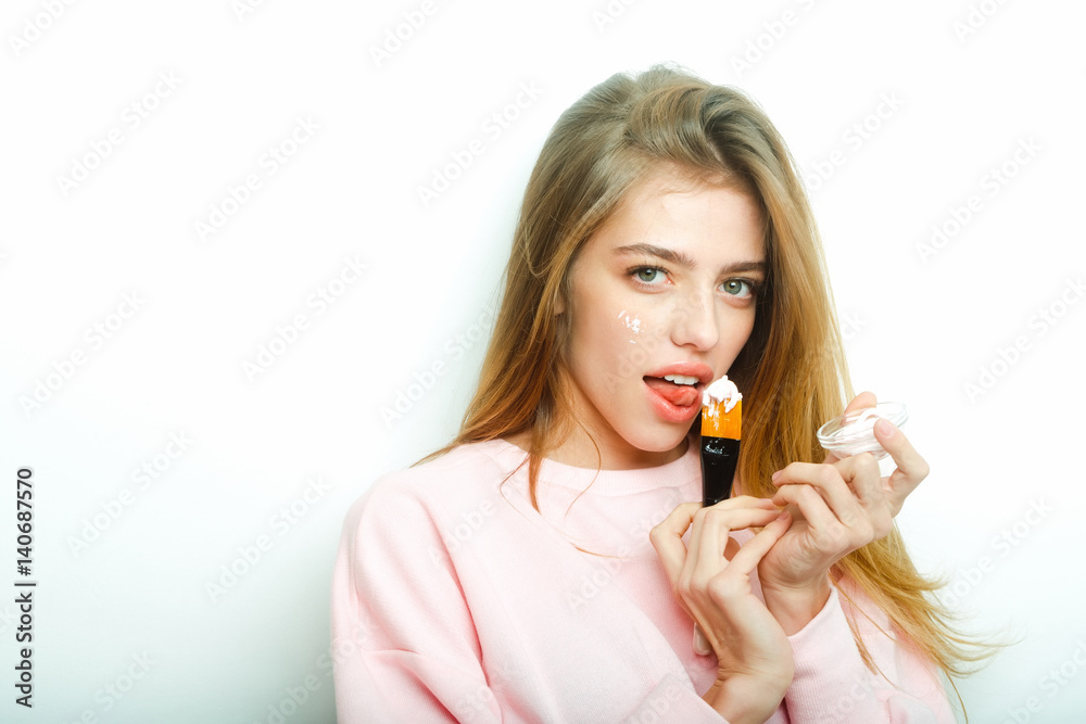 Pretty girl putting facial cream or mask on face skin Pretty girl putting facial cream or mask on face skin