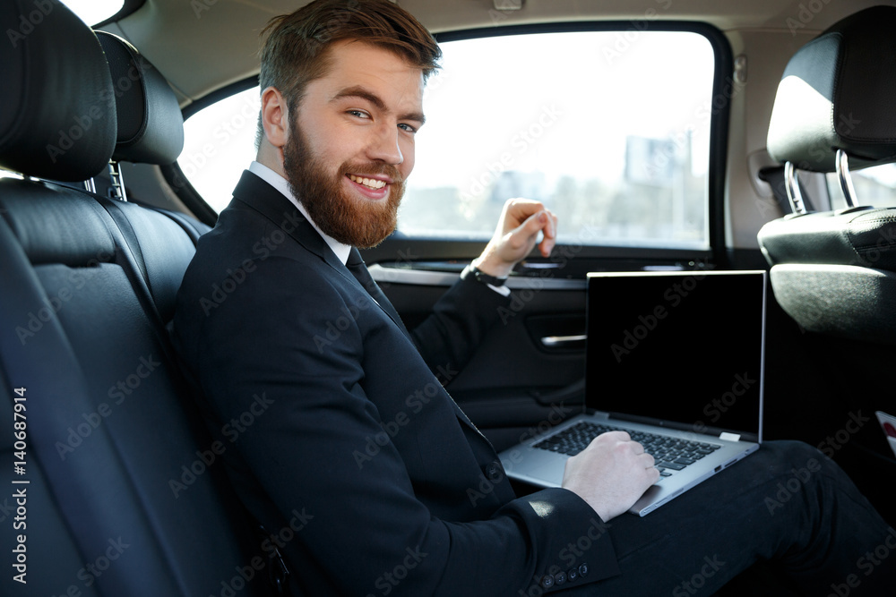 Side view of smiling business man with laptop