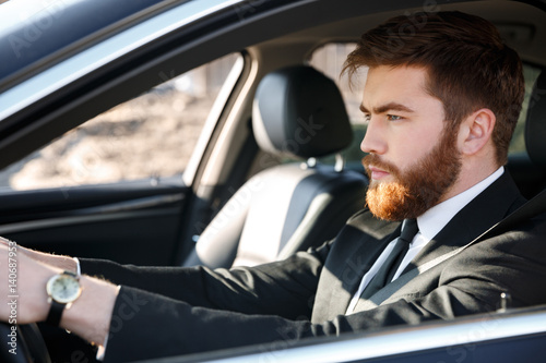 Close up portrait of serious business man driving car © Drobot Dean