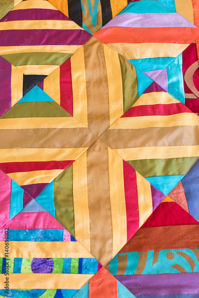 Obraz premium Part of symmetric geometry pattern color patchwork quilt as background. Colorful Scrappy blanket. Handmade.