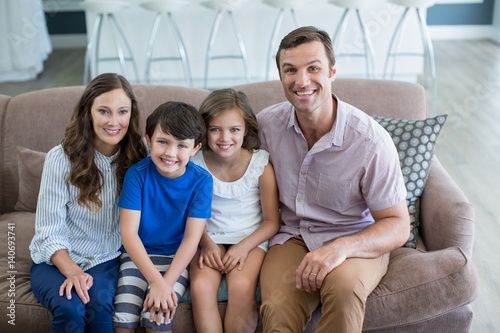 Portrait of smiling family sitting on sofa in living room