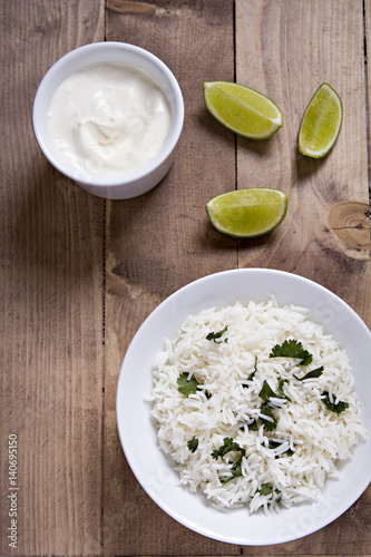 Bowl of rice, sour cream dip and lime wedges