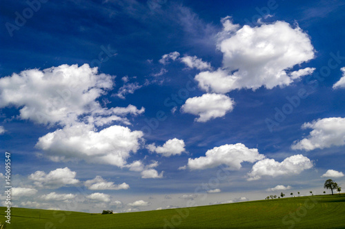 grüne Felder, tiefhängende, weisse Wolken am blauen Himmel, Ö