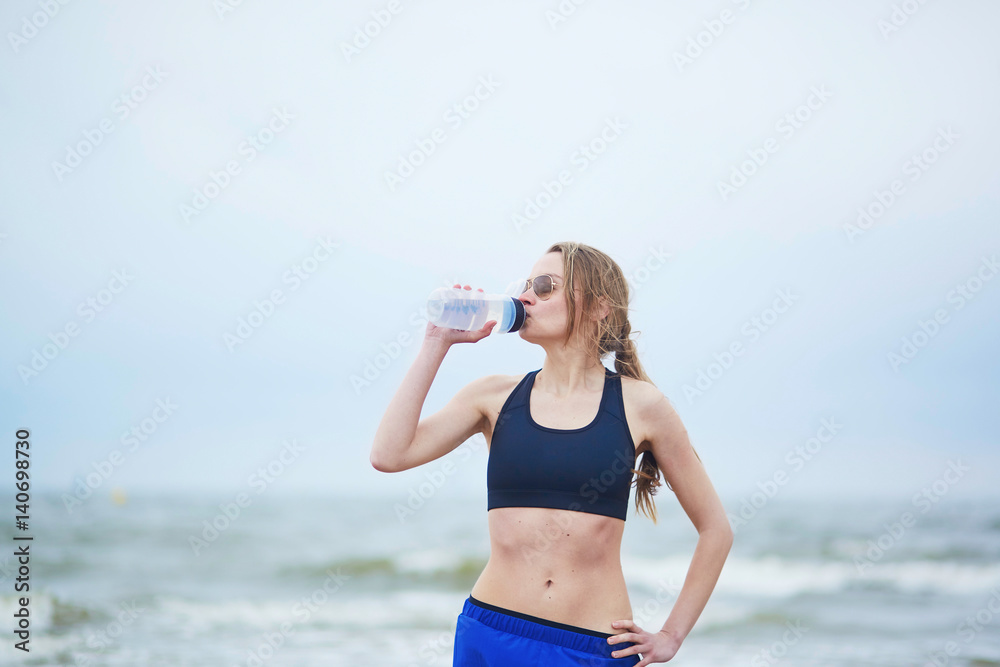 Runner girl drinking water from on running break Runner girl drinking water from on running break