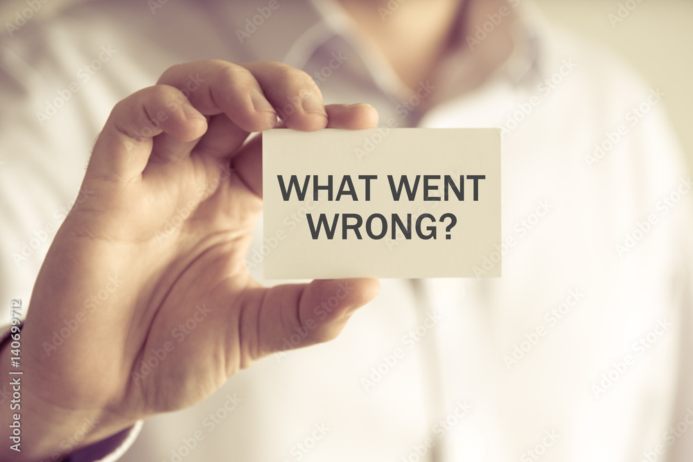 Businessman holding WHAT WENT WRONG ? message card Businessman holding WHAT WENT WRONG ? message card