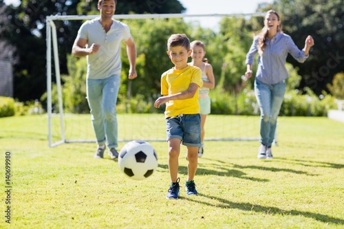 Happy family playing football in park