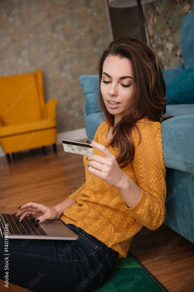 Φωτογραφία Portrait of a woman shopping on line holding credit card
