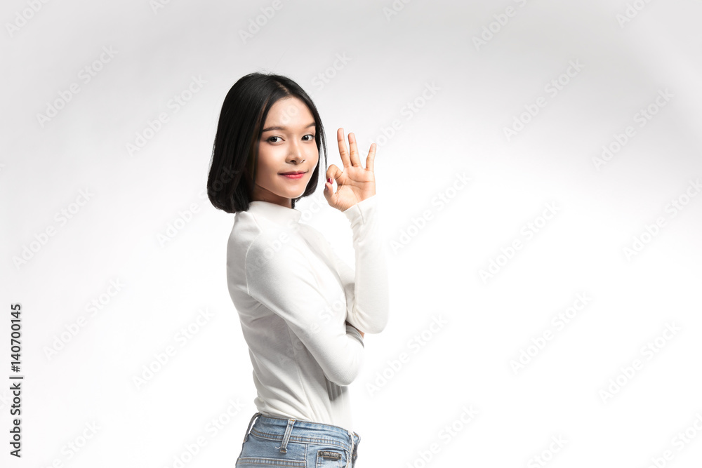 Beautiful asian girl making OK sign on white background Beautiful asian girl making OK sign on white background