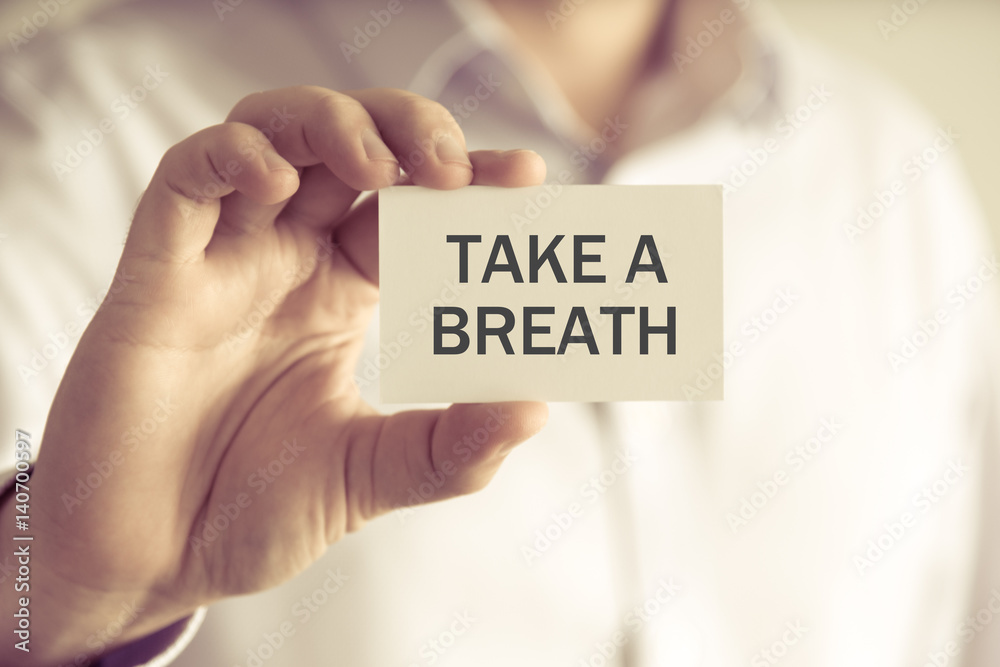 Businessman holding TAKE A BREATH message card Businessman holding TAKE A BREATH message card
