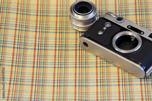 Old film camera against the background of a vintage suitcase