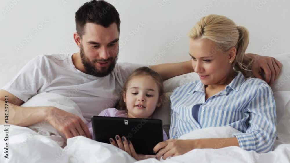 happy family with tablet pc in bed at home happy family with tablet pc in bed at home