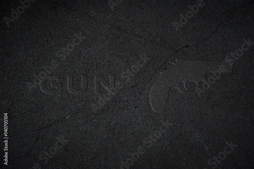 Wallpaper Mural Umriss einer Waffe in schwarzem Stein mit dem Wort GUN daneben Torontodigital.ca