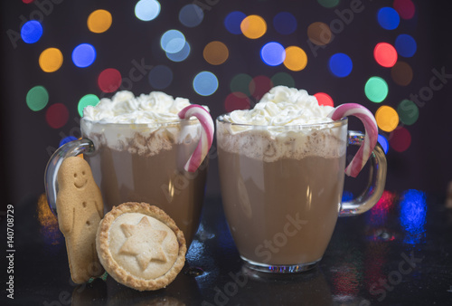 Hot chocolate with cream, candy canes, mine pies and gingerbread men photo