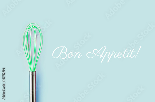 Fototapeta Neon green culinary whisk top view on colorful background