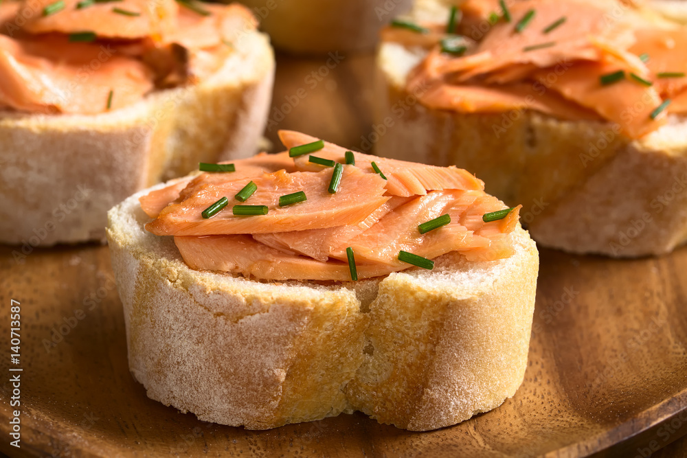 Smoked salmon sandwiches with chives, photographed with natural light (Selective Focus, Focus on the front of the salmon on the first bread) Smoked salmon sandwiches with chives, photographed with natural light (Selective Focus, Focus on the front of the salmon on the first bread)