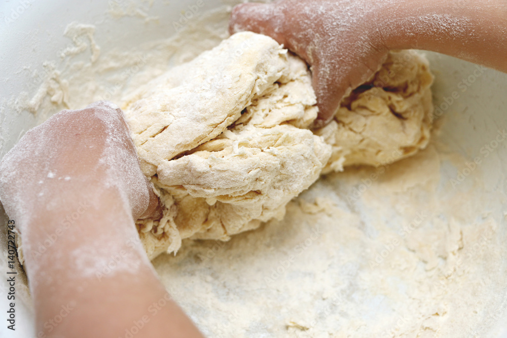Child hands knead the dough Child hands knead the dough
