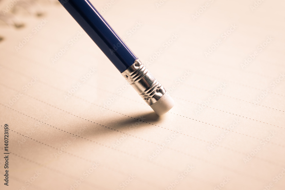 pencil eraser removing a written mistake on a piece of paper, delete, correct, and mistake concept. pencil eraser removing a written mistake on a piece of paper, delete, correct, and mistake concept.
