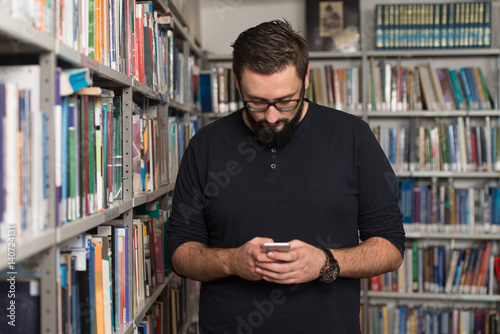 Handsome Male College Student Typing On Mobile Phone