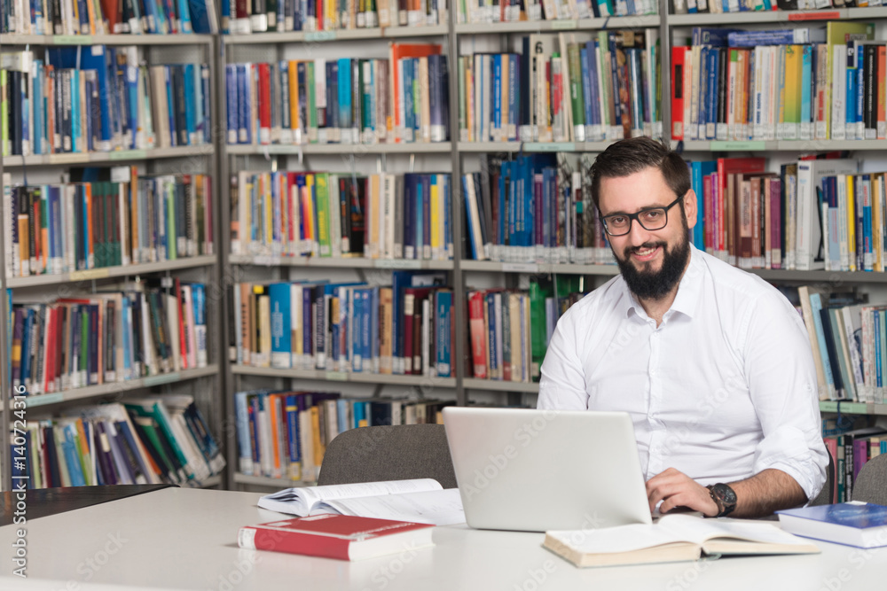 © Jale Ibrak - Young Student Using His Laptop In A Library