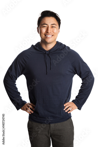 Fotografie An attractive man in his 20s standing against a white background wearing a blue hood shirt smiling, looking at camera