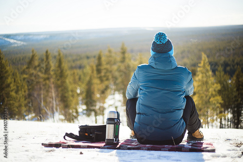 The man sits on a mountain in the forest photo