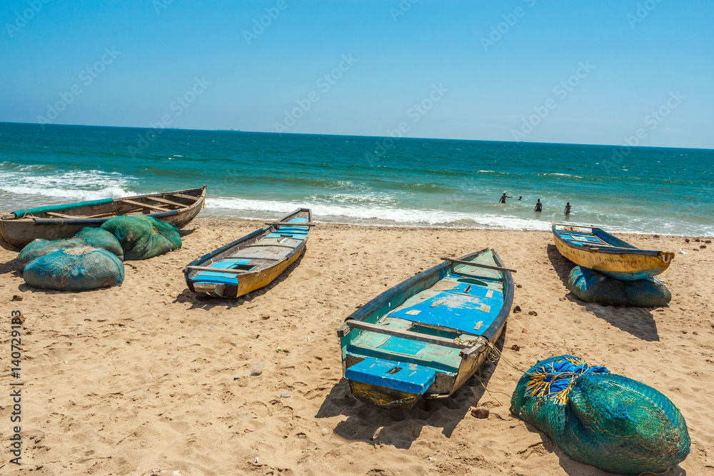 Wide view of group of fishing boats parked alone in seashore with people in the background, Visakhapatnam, Andhra Pradesh, March 05 2017 Wide view of group of fishing boats parked alone in seashore with people in the background, Visakhapatnam, Andhra Pradesh, March 05 2017