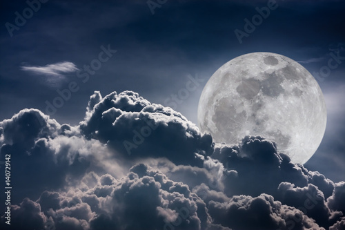 Nighttime sky with clouds and bright full moon with shiny. Vintage tone effect.