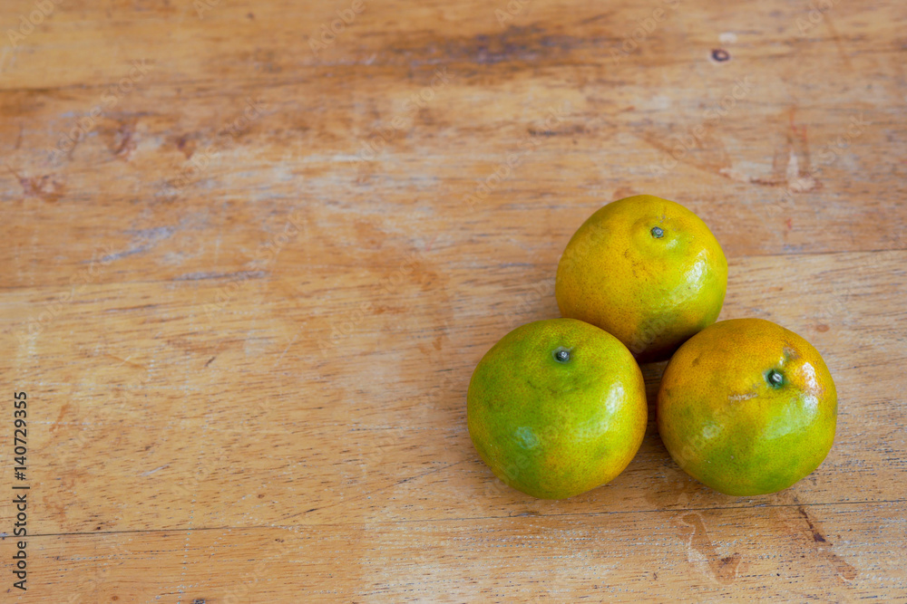 Green orange fruit on a wood table Green orange fruit on a wood table